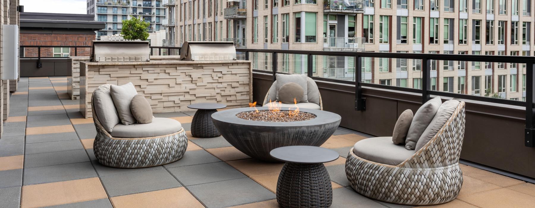 a balcony with a firepit and chairs